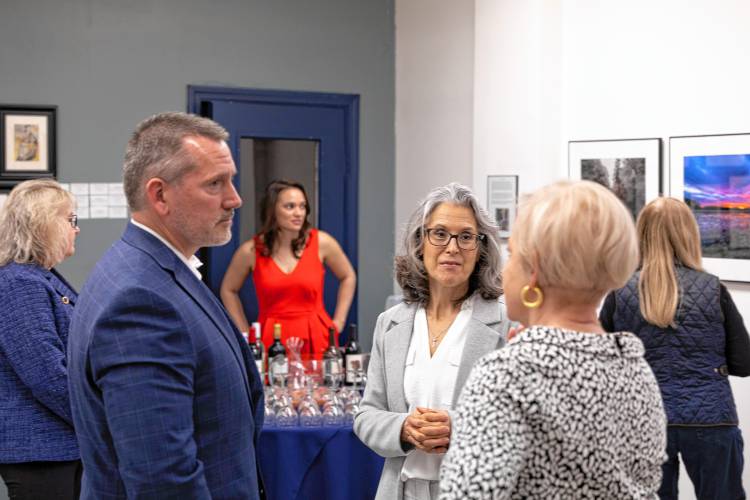 Aaron Carr, left, chats with guests and other artists at an opening in February. 