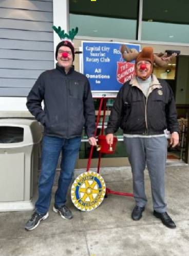 Capital City Sunrise Rotarians Mike Manning and Rich Berryman ring the Salvation Army collection bells at Exit 17 Market Basket with holiday style.