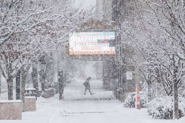 A pedestrian makes their way along 2nd Street SE as snow falls in Cedar Rapids, Iowa, on Tuesday, Jan. 9, 2024. A winter storm brought nearly a foot of snow to much of Iowa. (Nick Rohlman/The Gazette via AP)