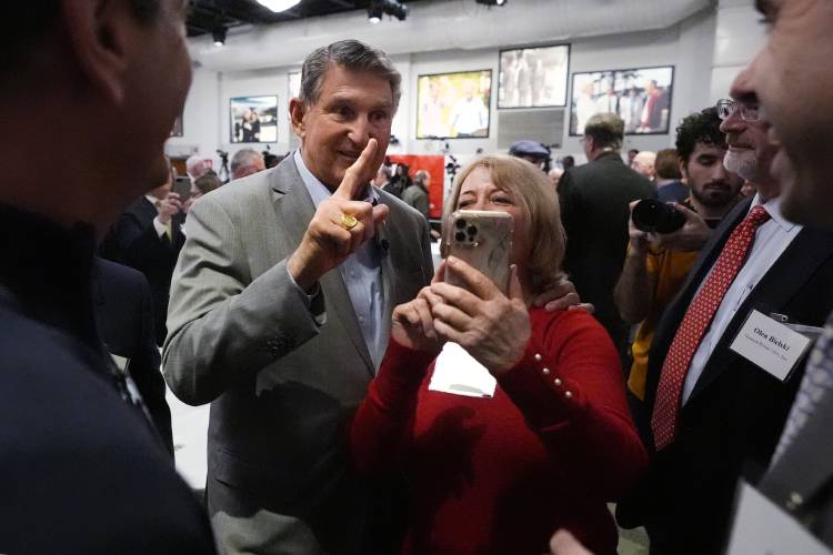 Sen. Joe Manchin, D-W.Va., left, poses with guests during the Politics and Eggs event, as part of his national listening tour, Friday, Jan. 12, 2024, in Manchester, N.H. Manchin announced last November that he would not seek reelection in 2024 and has teased a potential third-party run for the presidency. (AP Photo/Charles Krupa)