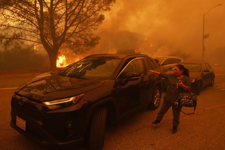A woman cries as the Palisades Fire advances in the Pacific Palisades neighborhood of Los Angeles Tuesday, Jan. 7, 2025. (AP Photo/Etienne Laurent)