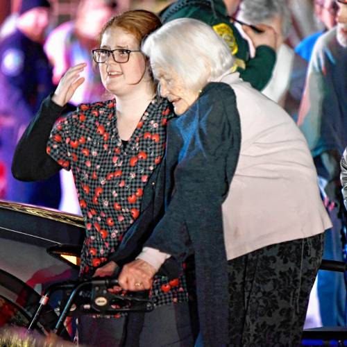 Medical staff help residents evacuate the Granite Ledges on Friday night after a two-alarm fire caused them to go into the street before being bused over to Concord Hospital.