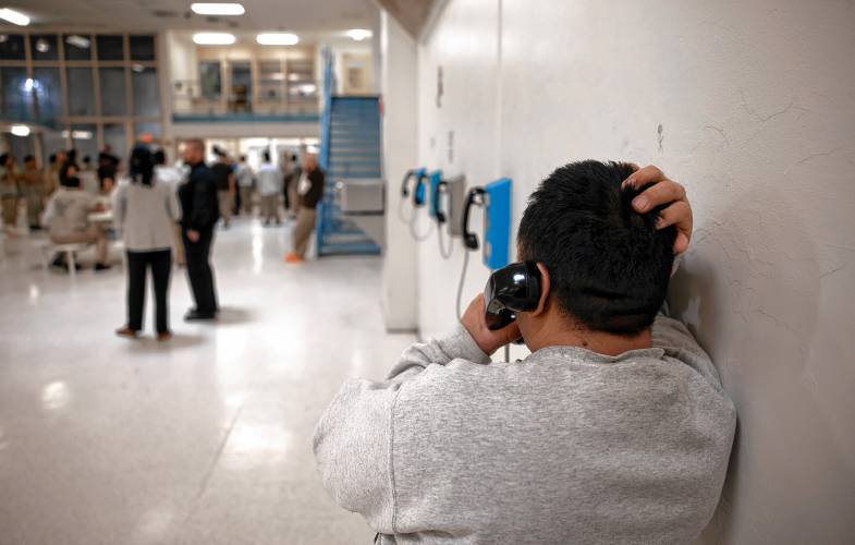 A Strafford County Jail inmate uses a phone in one of the units with a high percentage of inmates brought in by U.S. Immigrations and Customs Enforcement.