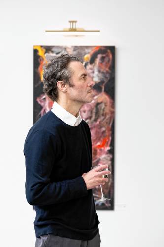 Charles Hanchett stands in front of his painting while looking at Erica Bodwell’s work.