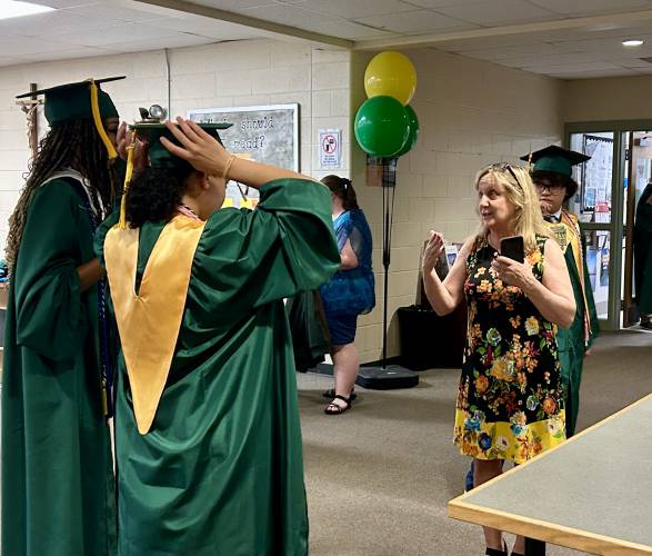 Principal Andrea Elliot explains to graduating seniors how to move their tassels from right to left, ahead of the Bishop Brady High School graduation in Concord on Friday, June 6, 2025.