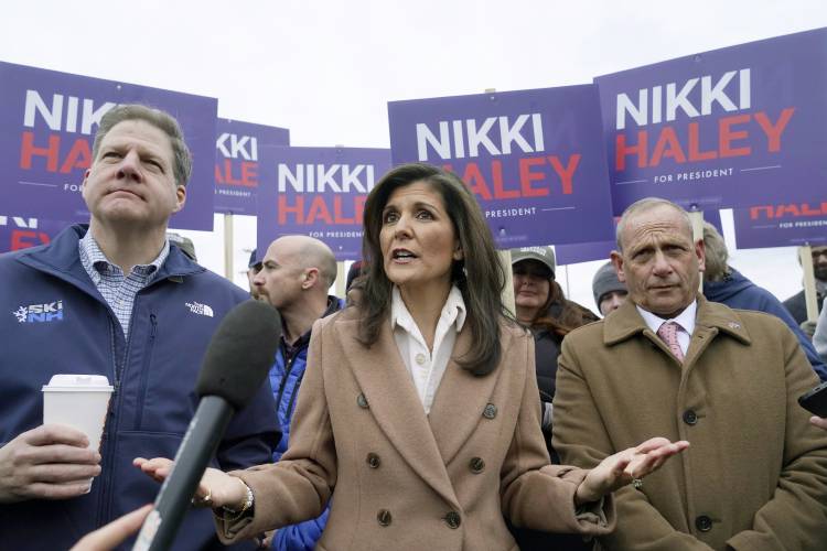 Republican presidential candidate former U.N. Ambassador Nikki Haley, center, addresses members of the media while standing with N.H. Gov. Chris Sununu, left, and retired U.S. Army Brig. Gen. Donald Bolduc, right, Tuesday, Jan. 23, 2024, near a polling site at Winnacunnet High School in Hampton, N.H. (AP Photo/Steven Senne)