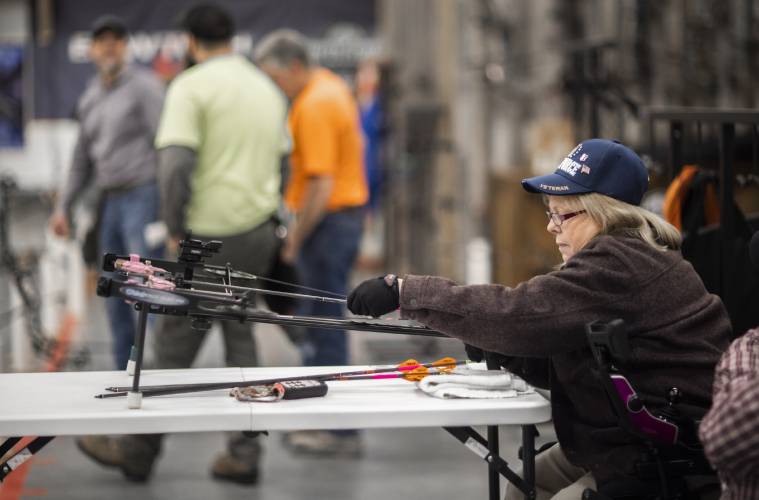 Melinda Simms gets ready to shoot with her custom bow at Coyote Creek Archery in Rochester on Thursday, February 1, 2024.