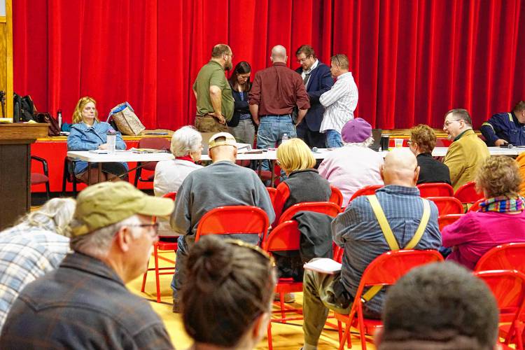 LEFT: Chichester town officials and counsel huddle during one of several recesses in a lengthy town meeting.