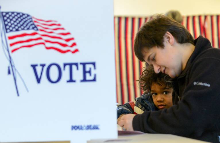 Levi Canon, 5, of Chesterfield, N.H., watches his mother, Bethany, fill out her ballot in the New Hampshire primary on Tuesday, Jan. 23, 2024. (Kristopher Radder /The Brattleboro Reformer via AP)