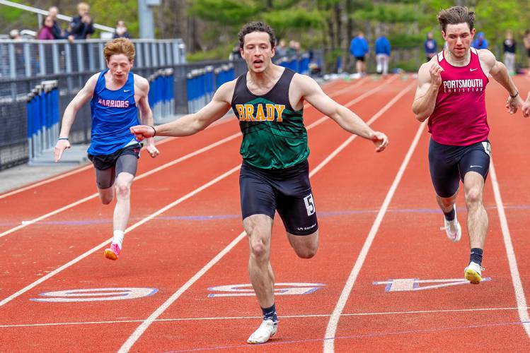 Bishop Brady's Josh Gentchos (center) crosses the finish line to win the 100-meter dash finals in 11.19 seconds at the 19-team Bobcat Invitational on Saturday at Oyster River High School in Durham. 