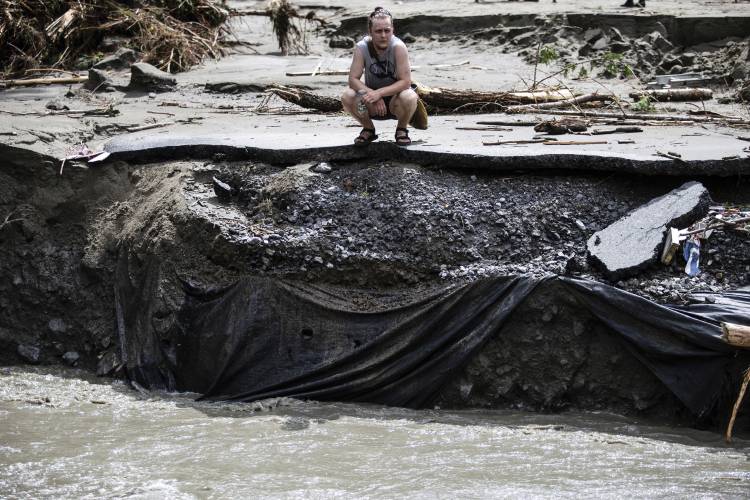 FILE - An overwhelmed resident surveys the damage following flooding caused by the remnants of Hurricane Beryl, Thursday, July 11, 2024, in Plainfield, Vt. On Wednesday, July 24, Vermont opened the first of four flood recovery centers while officials waited to find out whether the state qualifies for federal help through a disaster declaration. (AP Photo/Dmitry Belyakov, File)