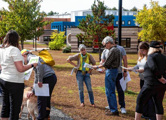  Participants look over maps of the trails behind Mill Brook and Broken Ground schools as they begin the tour for the middle school proposed site on Saturday, Sept. 28.