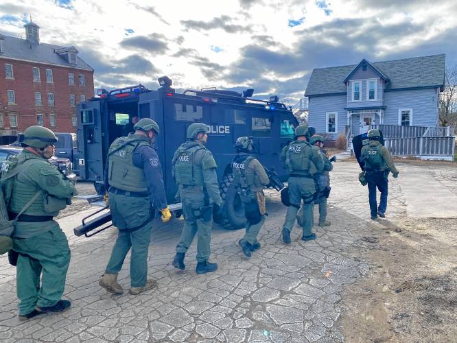 A team prepares to enter a barricade situation at the home at 120 Pleasant St. Monday afternoon.