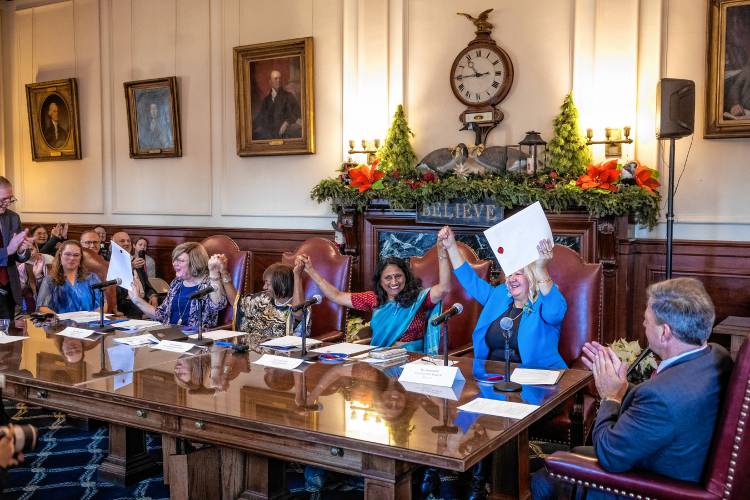 Governor Chris Sununu leads the applause as Electors Gerri Cannon,  Jacqueline Weatherspoon, Latha Mangipudi, and Eva Castillo-Turgeon hold up their certified documents for the four electors cast ballots on behalf of Vice President Kamala Harris and Minnesota Gov. Tim Walz, the Democratic vice presidential nominee, in a ceremonial vote at the Executive Council chamber on Dec. 17.