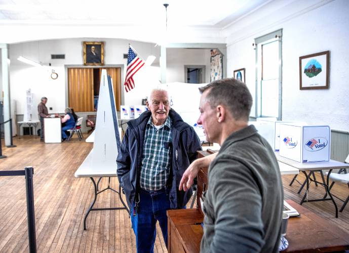 Salisbury town moderator David Hostetler talks with Bob Dukette after Dukette voted at the town hall on Tuesday, March 11, 2025. A team of town officials will re-fit the room for the town meeting later in the day.