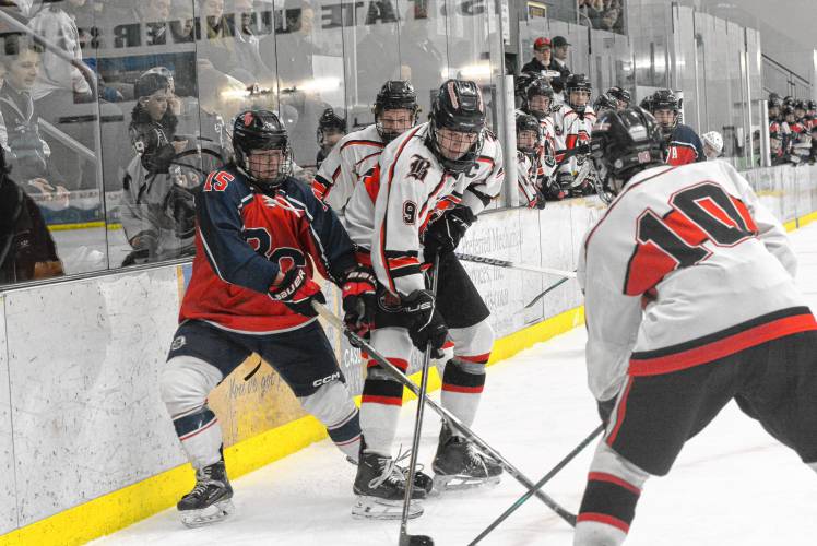 Belmont-Gilford’s Ethan Girard (15) battles along the boards with Berlin-Gorham's Hudson Goulet (9) during a Division III boys' hockey semifinal on Wednesday at Plymouth State University’s Hanaway Rink. No. 4 Belmont-Gilford upset No. 1 Berlin-Gorham, 3-2, to advance to its third finals appearance in four years.