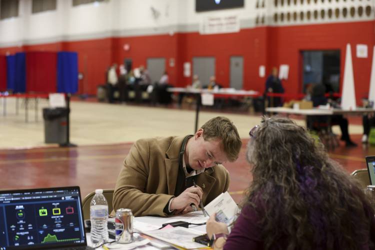 Michael Appleton registers to vote in Derry, N.H., Tuesday, March 11, 2025. (AP Photo/Reba Saldanha)