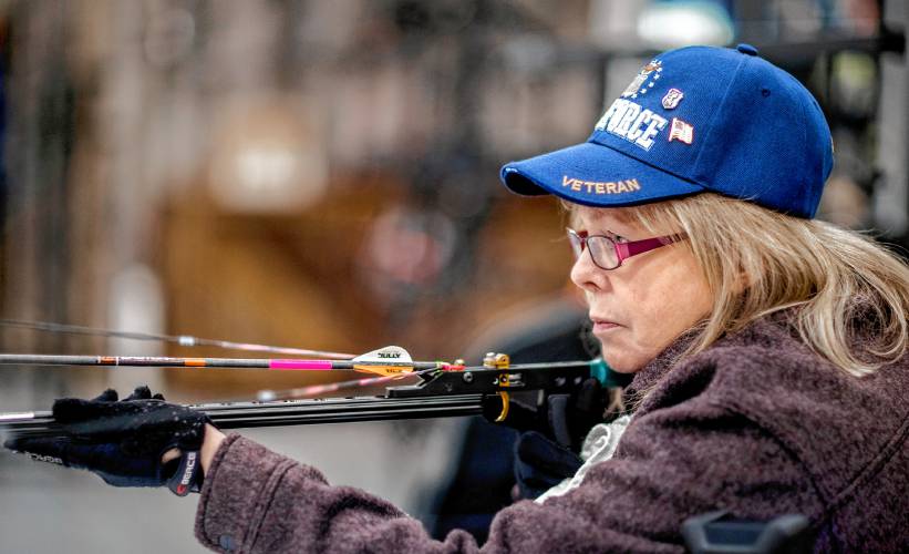 Melinda Simms gets ready to shoot with her custom bow at Coyote Creek Archery in Rochester on Thursday.