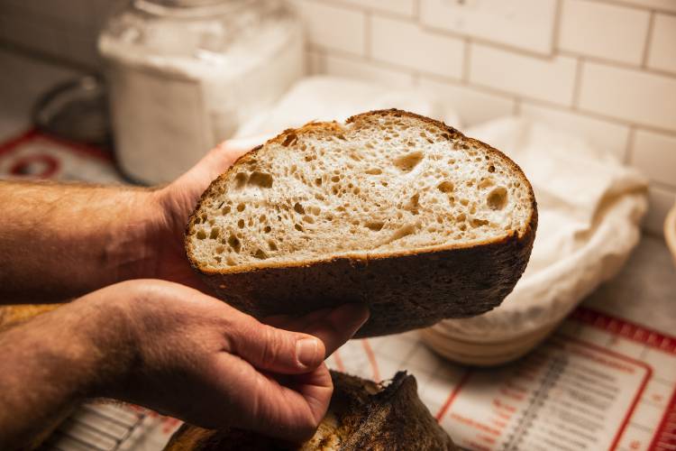 Alex Brown with his signature bread he makes at his South End home. Brown is getting a new bread oven to increase his weekly output.