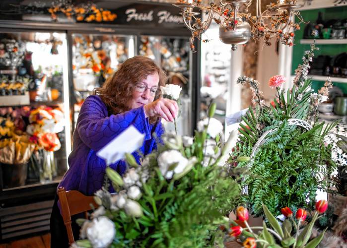 Lorrie Carey, owner and operator of Marshall’s Florist in Boscawen, puts the final touches of making a bouquet of flowers on Thursday, November 16, 2023. The florist will be closing down in the new year.