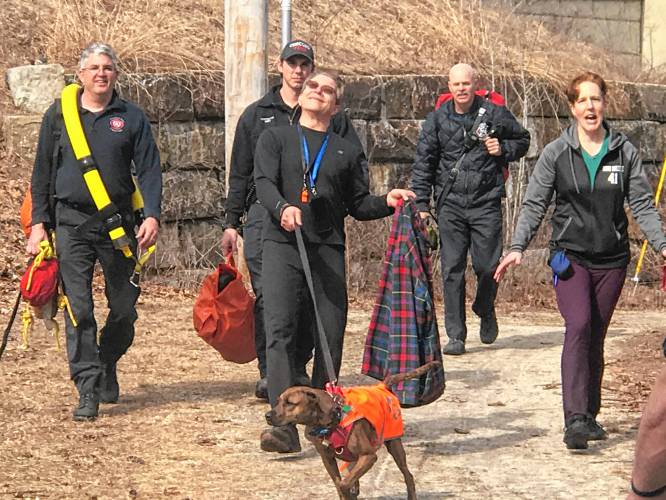 Elated Rob Cary emerges from a trail with his dog Zoe, new friend Taury Anderson and rescue personnel after a harrowing ordeal on Wednesday in Concord.