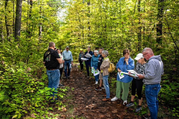 Participants look over maps on the trails behind Millbrook and Broken Ground schools as they tour the site for the proposed middle school on Saturday, September 28, 2024.