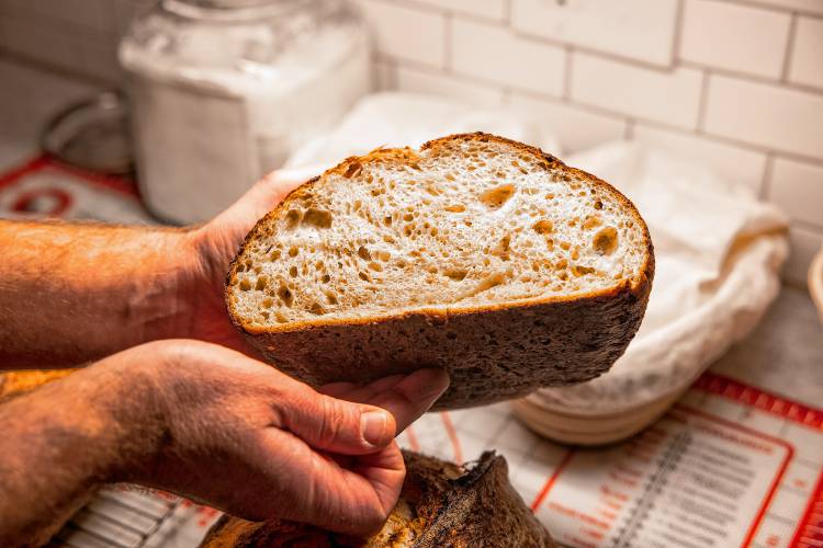Alex Brown with his signature bread he makes at his South End home. Brown is getting a new bread oven to increase his weekly output.
