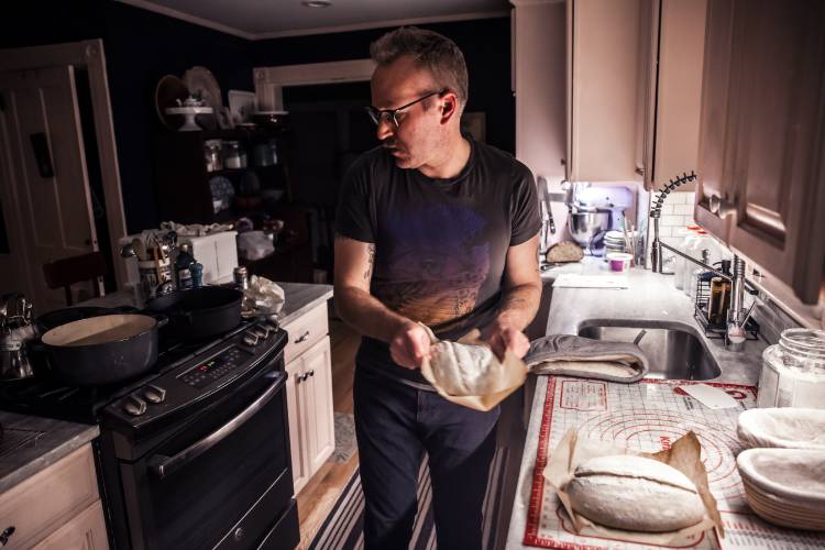 Alex Brown gets ready to put the dough for his bread into the oven at his South End home. Brown is getting a new bread oven to increase his weekly output. To give a boost to homestead kitchens, New Hampshire lawmakers are eyeing changes to regulations.