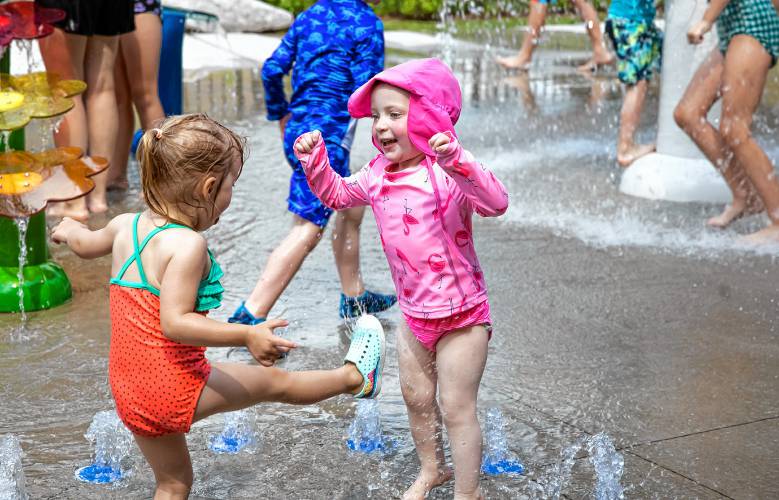 Nora Conway, 2, jumps with a friend at the White Park splash pad on Tuesday,  as the temperatures reached the middle 90s by the time the pad was turned on. Conway’s parents are teachers so they get time to enjoy the summer with their daughter.