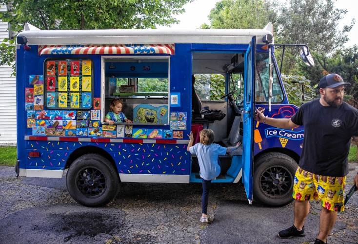 Adam Gelinas loads up their van to drive around in the neighborhood near where they live in Allenstown on Thursday evening, August 22, 2024. The whole family was there to help sell ice cream to the area.