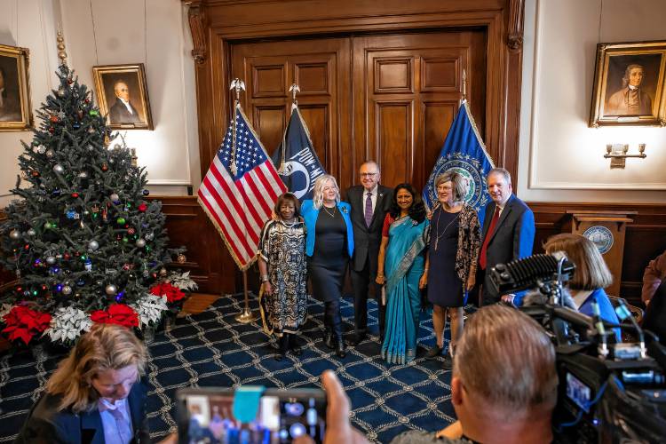 Electors Jacqueline Weatherspoon (left), Eva Castillo-Turgeon, Latha Mangipudi, Gerri Cannon, stand with Democratic Chairman Ray Buckley (center) and Secretary of State David Scanlan after the ceremon as  the four electors cast ballots on behalf of Vice President Kamala Harris and Minnesota Gov. Tim Walz, the Democratic vice presidential nominee, in a ceremonial vote at the Executive Council chamber on Dec. 17.