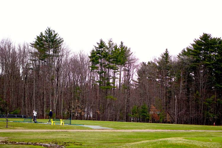 Golfers at the driving range at Beaver Meadow Golf Course on a rainy afternoon in April. Golfers at the driving range at Beaver Meadow Golf Course on a rainy afternoon in April.