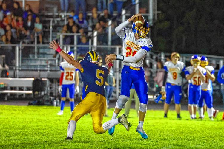Gilford-Belmont QB Anakin Underhill jukes away from Bow's Josiah Funches during Friday night's game. September 15, 2023.