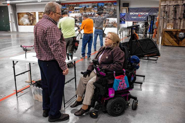 Melinda Simms talks with husband, Rodney, as she gets ready to shoot with her custom bow at Coyote Creek Archery in Rochester on Thursday, February 1, 2024.