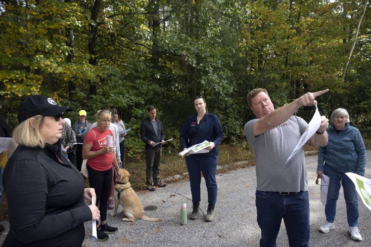 Jack Dunn, the SAU 8 business administrator, uses a map to show the participants of the new middle school site tour the land as they stand on North Curtisville Road which is near the proposed site for the school.