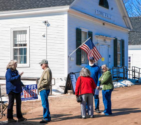 Select Board candidate Rose Fife (left), talks with Dave Merwin as Gail Henry (center) talks with Ed and Linda Denoncourt outside the Salisbury Town Hall during lunchtime voting on Tuesday, March 11, 2025.