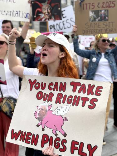 Alyssa Boyd from Washington, New Hampshire shouts at the passing traffic on Main Strreet in Concord during the latest ‘Hands Off’ protest at the State House on Saturday, April 19, 2025.