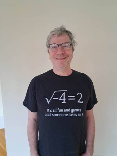 Dean Rubine with a T-shirt carrying a mathematics joke about imaginary numbers.