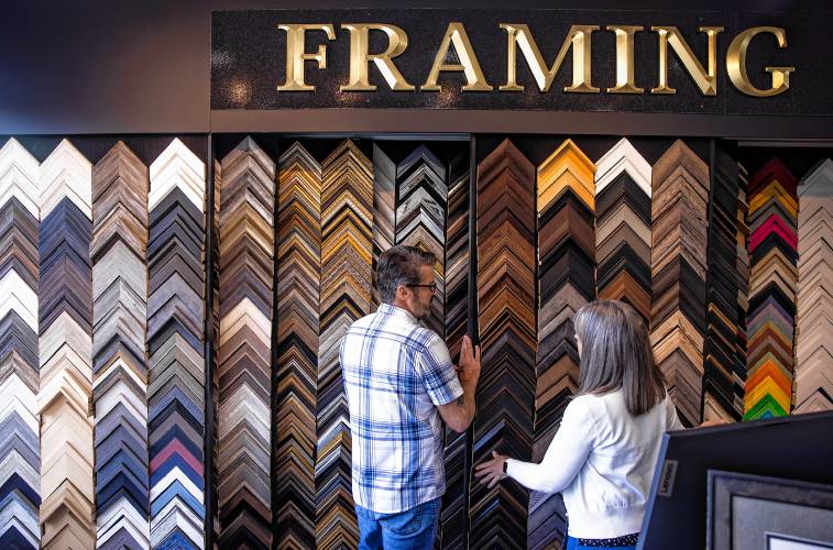 Scott and Karen Walton look over the hundreds of frames at their custom framing Rowland Studio on Fort Eddy Road in Concord.