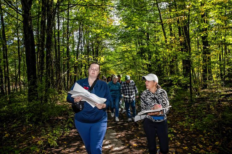 Norbis project engineer Morgan Dunson (left) and Ward Five City Councilor Stacey Brown look over maps as they walk the trail where the proposed new middle school would be located during a tour of the area on Saturday, September 28, 2024.