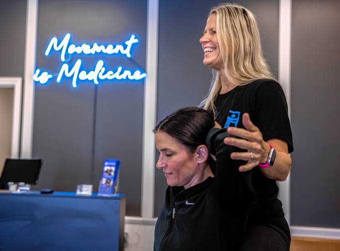 Staff member Karen Kenney demonstrates their stretching technique on fellow staffer Cara Boggs at the Flexable Assisted Stretching and Wellness on Sheep Davis Road in Concord.