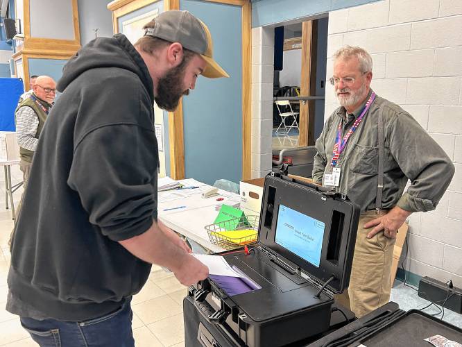 A voter submits his ballot in Boscawen.