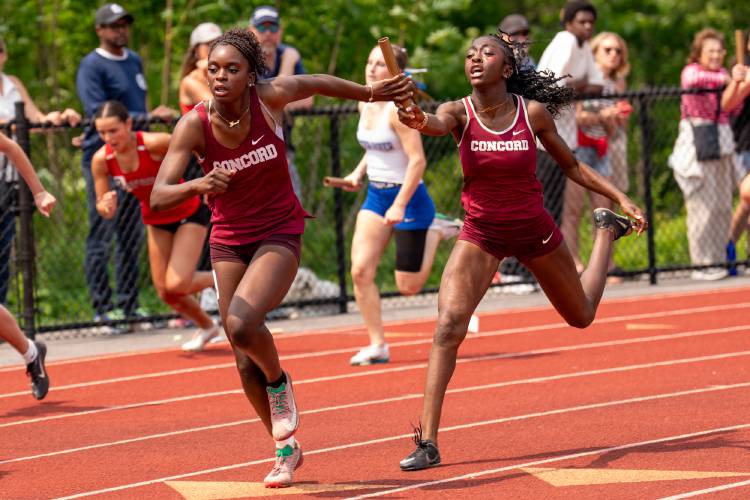 Concord’s Grace Saysaw (left) receives the baton from teammate Ballay Conteh in the 4x100-meter relay at the Meet of Champions on Sunday at Oyster River High School. Saysaw anchored both the 4x100 and 4x400 relays, and also won the 100 and 200.