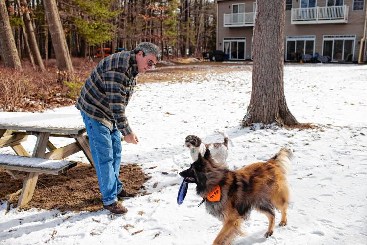 Dennis Pratt plays catch with his dogs, Ron Paw and Janey at his condo near Dover Point in Dover on Thursday, February 1, 2024.