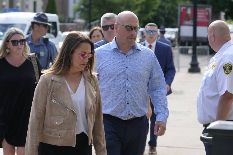 Paul O'Keefe, center, brother of the late Boston police Officer John O'Keefe, enters Norfolk Superior Court with his wife Erin O'Keefe, front left, Monday, July 1, 2024, in Dedham, Mass. Read is on trial, accused of killing her boyfriend John O'Keefe, in 2022. The jury began deliberations in the trial Tuesday, June 25. (AP Photo/Steven Senne)