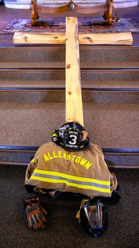 An Allenstown fire uniform, neatly folded at the base of a cross on the altar of  St. Johnâs the Baptist Catholic Church in Allenstown on Wednesday, September 11, 2024.