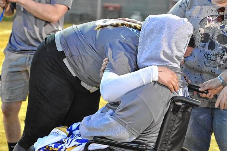 Lily Cornell (left) hugs her mother, Abby, after picking up her 500th career strikeout on Thursday. Franklin held a Strikeout Cancer fundraiser to support Abby, who is battling brain cancer.