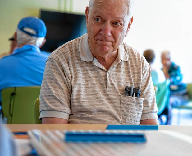 David Elberfeld plays Scrabble with a group of friends at the Concord Community Center on Monday morning.