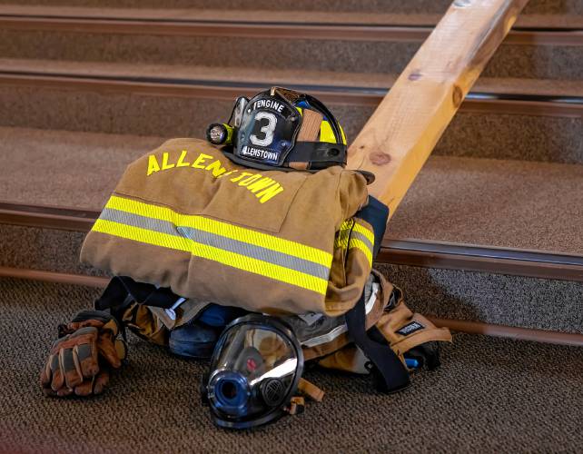 An Allenstown fire uniform, neatly folded at the base of the altar of  St. Johnâs the Baptist Catholic Church in Allenstown on Wednesday, September 11, 2024.