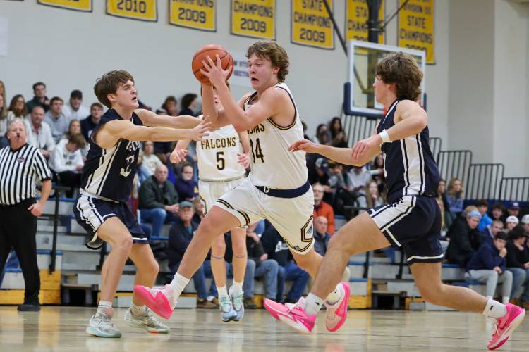Bow’s Jake Reardon splits through two Milford defenders as he drives to the basket during a game last season. Reardon, an All-State player, is back to lead the Falcons this season.